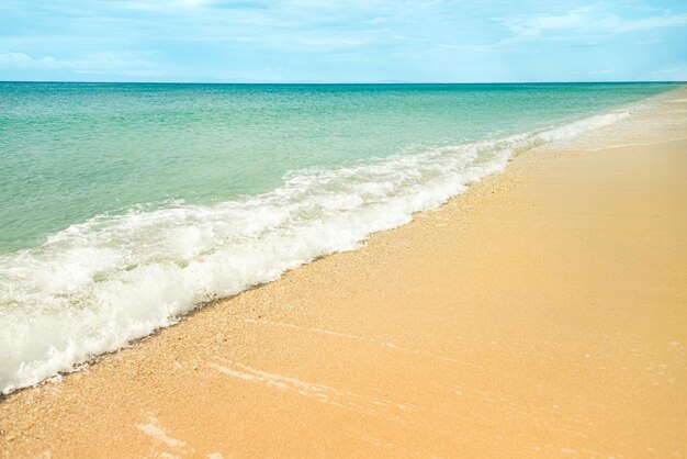 Praia de areia dourada e águas do mar turquesa salpicos de ondas suaves na costa do mar copiar espaço