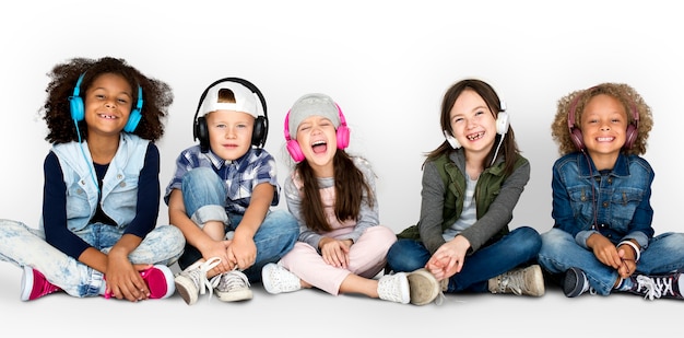 Grupa dzieci studio uśmiechnięte noszenie słuchawek i zimowe ubrania