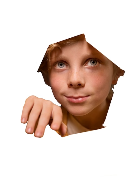 Bezpłatny plik PSD Ładny portret chłopca patrząc przez cięty papier