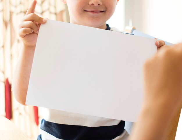 Mały chłopiec z pustym makieta papieru