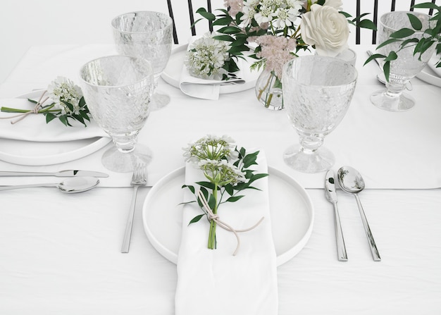 stół przygotowany do jedzenia ze sztućcami i ozdobnymi kwiatami