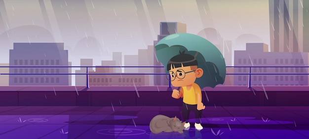 Chłopiec pod parasolem z bezdomnym kotem w jesiennym deszczu