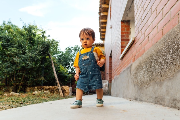 1-letnie dziecko stawia pierwsze kroki w ogrodzie swojego domu