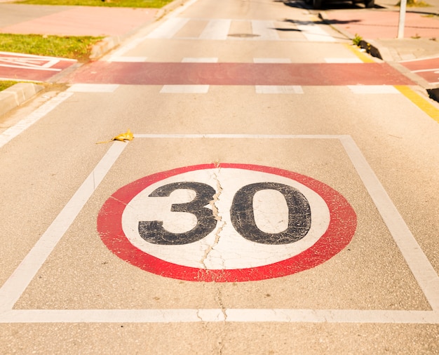 30 Znak ograniczenia prędkości na asfaltowej drodze