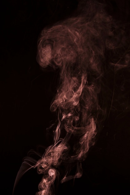 Abstrakcyjny wzór wykonany z dymu rośnie na czarnym tle
