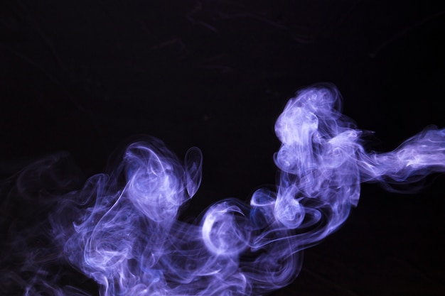 Abstrakt i tekstura purpurowy magiczny dym na czarnym tle