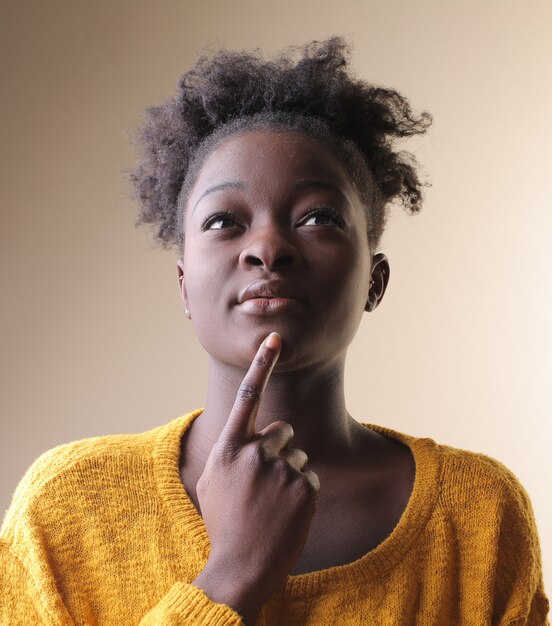 African American kobieta myśli z palcem na brodzie
