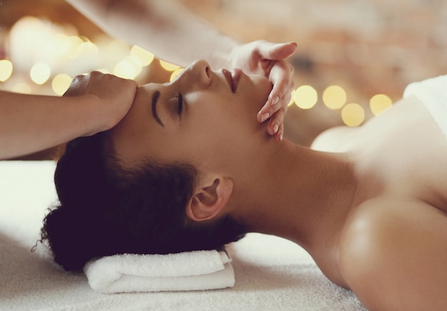 African American kobieta odbiera relaksujący masaż w spa