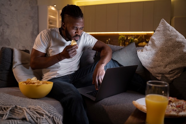 Bezpłatne zdjęcie afroamerykanin jedzący późno w nocy