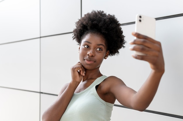 Bezpłatne zdjęcie afroamerykanka robi selfie swoim smartfonem