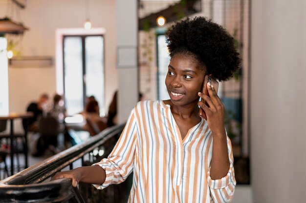 Afroamerykanka rozmawia z kimś na swoim smartfonie