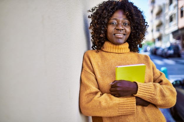Afroamerykanka Uśmiechnięta Pewna Siebie Trzymająca Książkę Na Ulicy