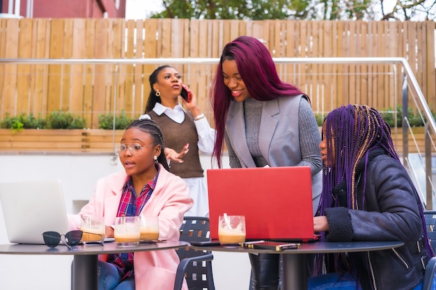Afroamerykanki na spotkaniu biznesowym w stołówce z laptopami i kawą na stole