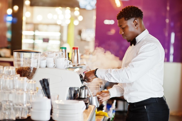 Afroamerykański barman barista w barze przygotowującym kawę