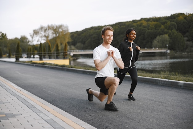 Afroamerykański model fitness i kaukaski mężczyzna trenujący na świeżym powietrzu