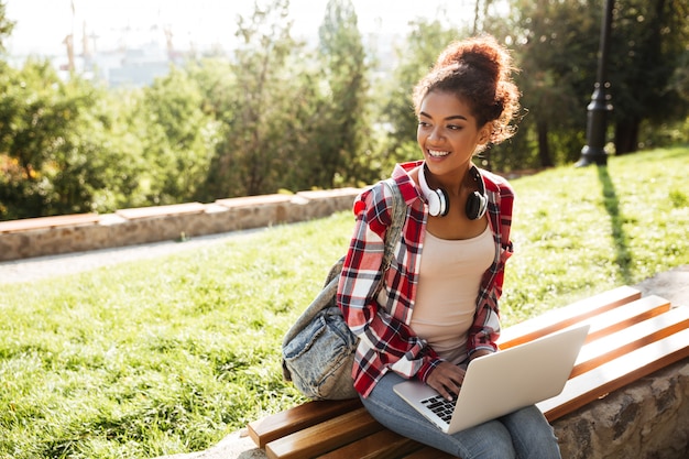 Afrykańska Kobieta Siedzi Outdoors W Parku Używać Laptop.