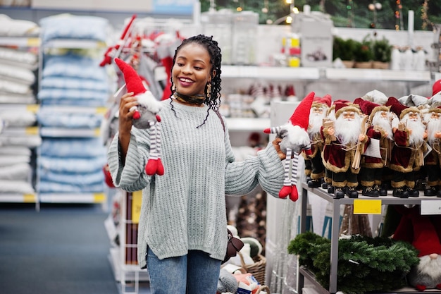 Afrykańska kobieta wybiera noworoczne rzeczy do swojego mieszkania w nowoczesnym sklepie z meblami domowymi Świąteczne zakupy