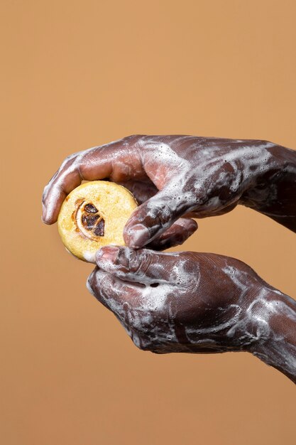 Afrykańska osoba myjąca ręce mydłem na pomarańczowym tle