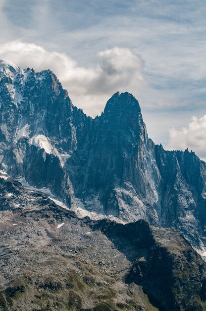 Aiguilles des Drus obok Aiguille Verte powyżej doliny Chamonix z chmurami i niebieskim niebem