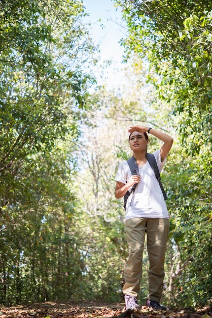 Aktywna młoda kobieta turystyka chodząca lasem cieszyć się przyrodą.