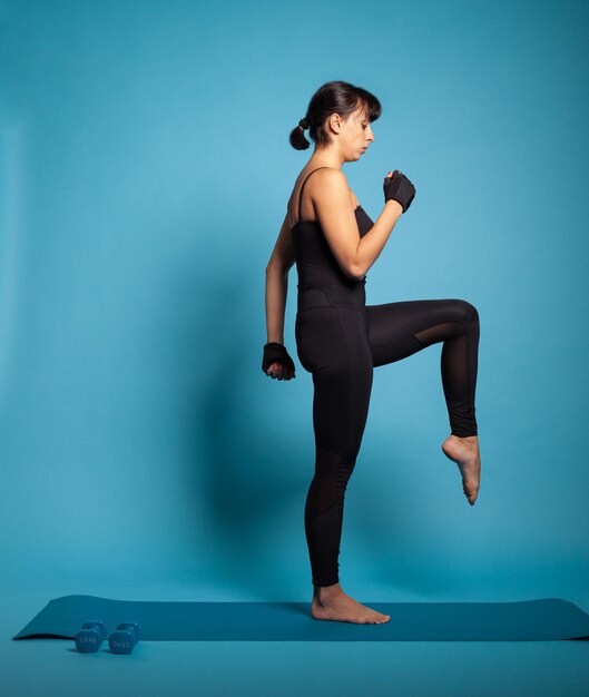 Aktywna osoba trenująca wytrzymałość ciała rozciągająca mięśnie nóg pracująca w zdrowym stylu życia. Trener personalny w odzieży sportowej wykonujący ćwiczenia gimnastyczne ćwiczące trening fitness. Koncepcja sportowa