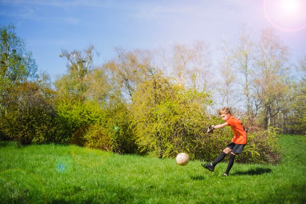 Aktywny chłopiec grający w piłkę nożną
