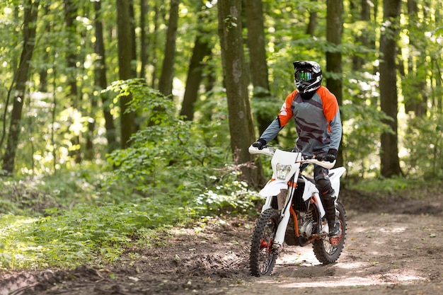 Aktywny mężczyzna jedzie motocykl w lesie