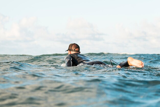 Aktywny mężczyzna w specjalnym sprzęcie przebywający na desce surfingowej