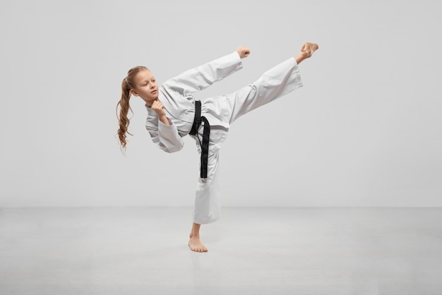 Aktywny żeński nastolatek ćwiczy karate w studiu