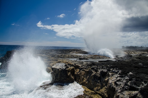 Alofaaga Blowholes pod słońcem i błękitne pochmurne niebo na Samoa