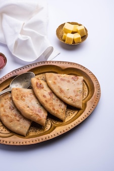 Aloo paratha lub gobi paratha znane również jako nadziewane ziemniaczane lub kalafiorowe danie z podpłomyków pochodzących z subkontynentu indyjskiego