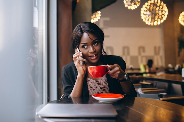 Amerykanin afrykańskiego pochodzenia biznesowa kobieta pracuje w kawiarni