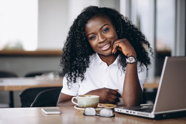 Amerykanin afrykańskiego pochodzenia biznesowa kobieta z komputerem i kawą