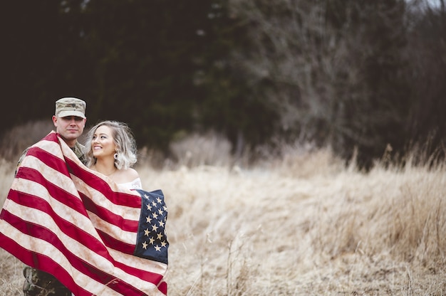 Amerykański żołnierz Z Uśmiechniętą żoną Owiniętą Amerykańską Flagą Darmowe Zdjęcia