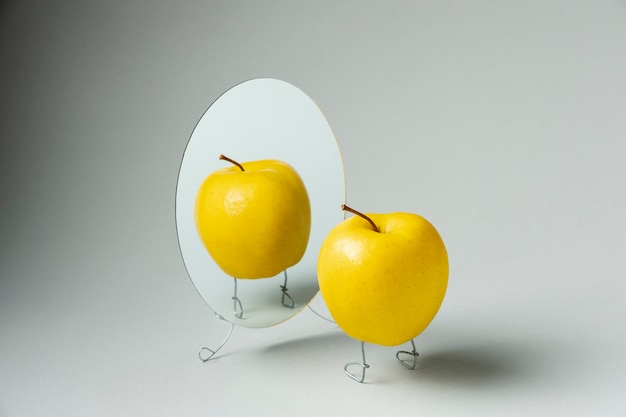 Bezpłatne zdjęcie animowane jabłko patrzące w lustro martwa natura