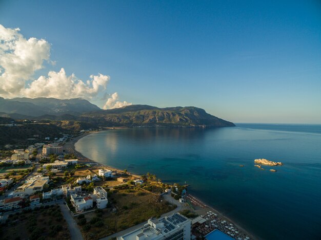 Antena strzelał domy na plaży pięknym spokojnym oceanem chwytającym w Karpathos, Grecja
