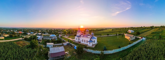 Bezpłatne zdjęcie antenowe drone panorama widok kościoła o zachodzie słońca. wioska w mołdawii