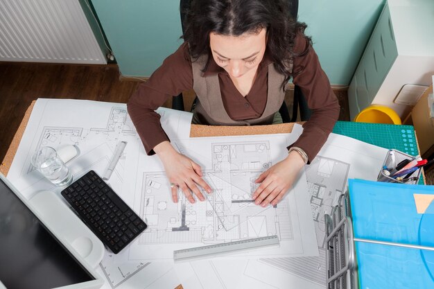 Architekt kobieta przy biurku pracuje nad planami. Biznes i kreatywność. Praca w architekturze