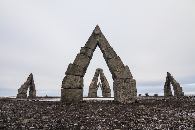 Bezpłatne zdjęcie arctic henge otoczony polem pokrytym śniegiem pod zachmurzonym niebem w islandii