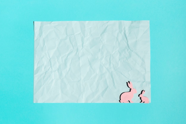 Arkusz papieru z małych drewnianych królików na stole