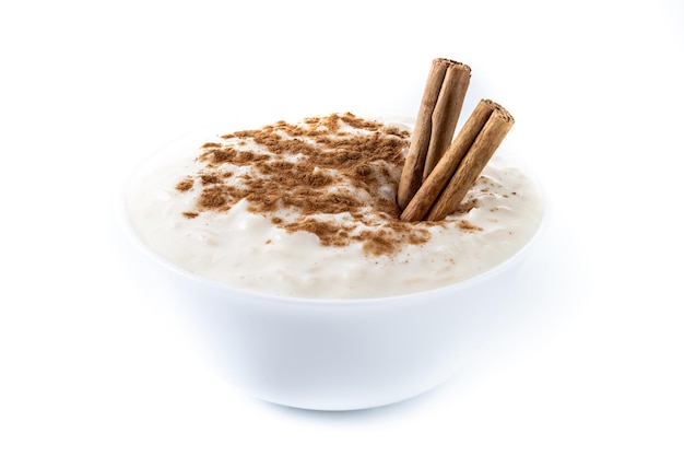 Bezpłatne zdjęcie arroz con leche pudding ryżowy z cynamonem w białej misce izolowany na białym tle