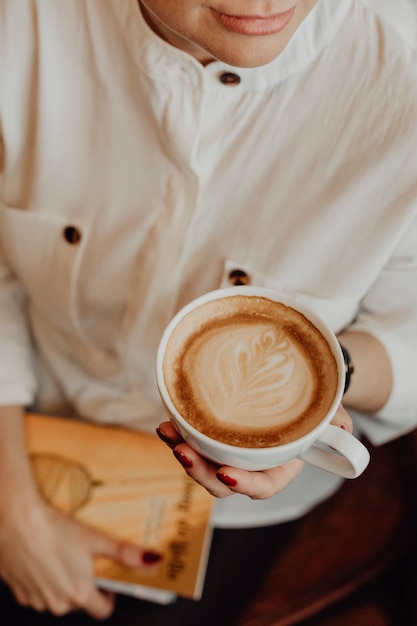 Bezpłatne zdjęcie artystyczna dziewczyna przy filiżance kawy