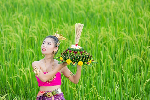 Bezpłatne zdjęcie asia kobieta w tradycyjnym stroju tajskim trzymać kratong. festiwal loy krathong