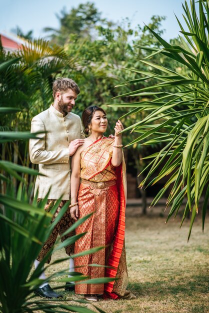 Asian bride and Caucasian groom mają romantyczny czas z Tajlandii sukienka