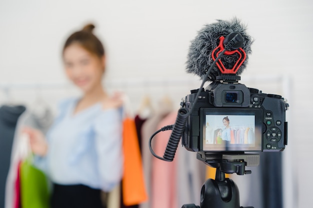 Asian fashion female blogger online influencer gospodarstwa torby na zakupy i mnóstwo ubrań