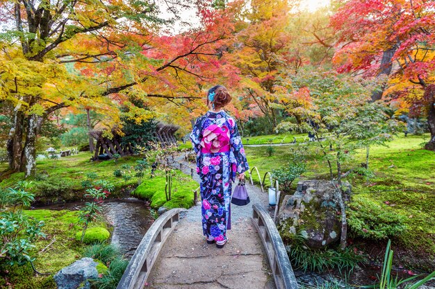 Asian kobieta ubrana w tradycyjne japońskie kimono w jesiennym parku. Kioto w Japonii.