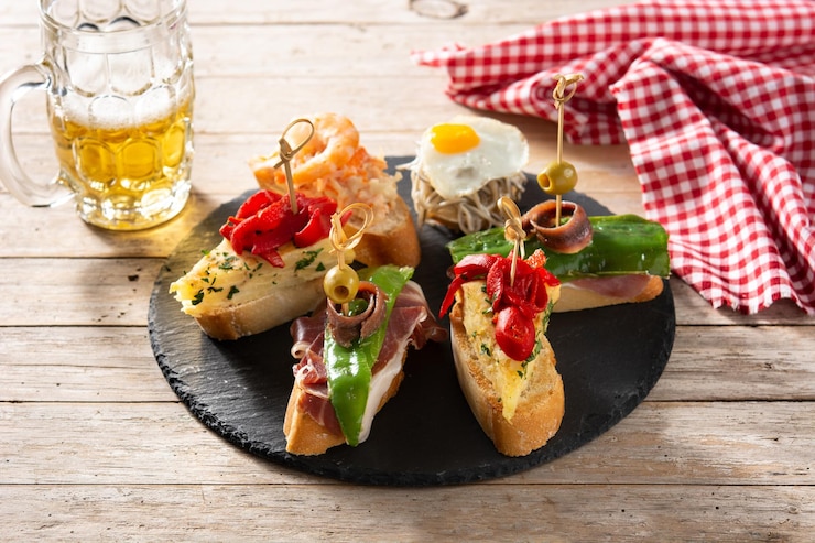 Bezpłatny plik Zdjęcie asortyment hiszpańskich pintxos na drewnianym stole typowe hiszpańskie jedzenie