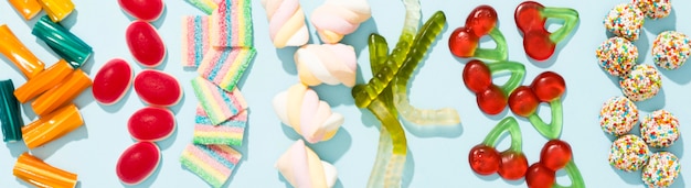 Asortyment kolorowych cukierków na niebieskim tle z miejsca na kopię