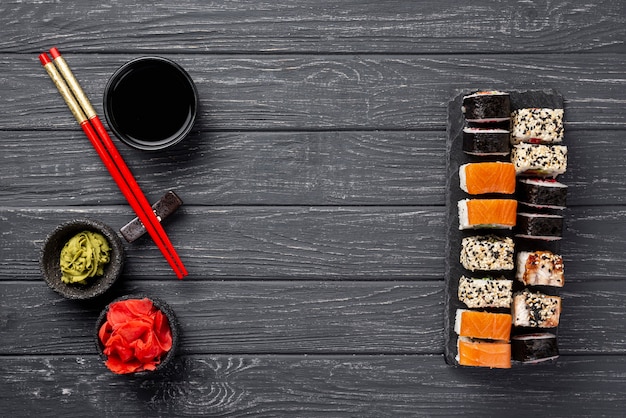 Asortyment maki sushi na płasko leżący na łupku pałeczkami