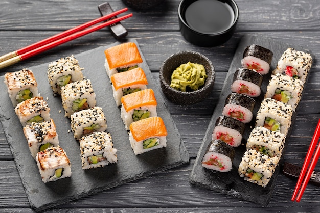 Bezpłatne zdjęcie asortyment maki sushi pod dużym kątem na łupku pałeczkami